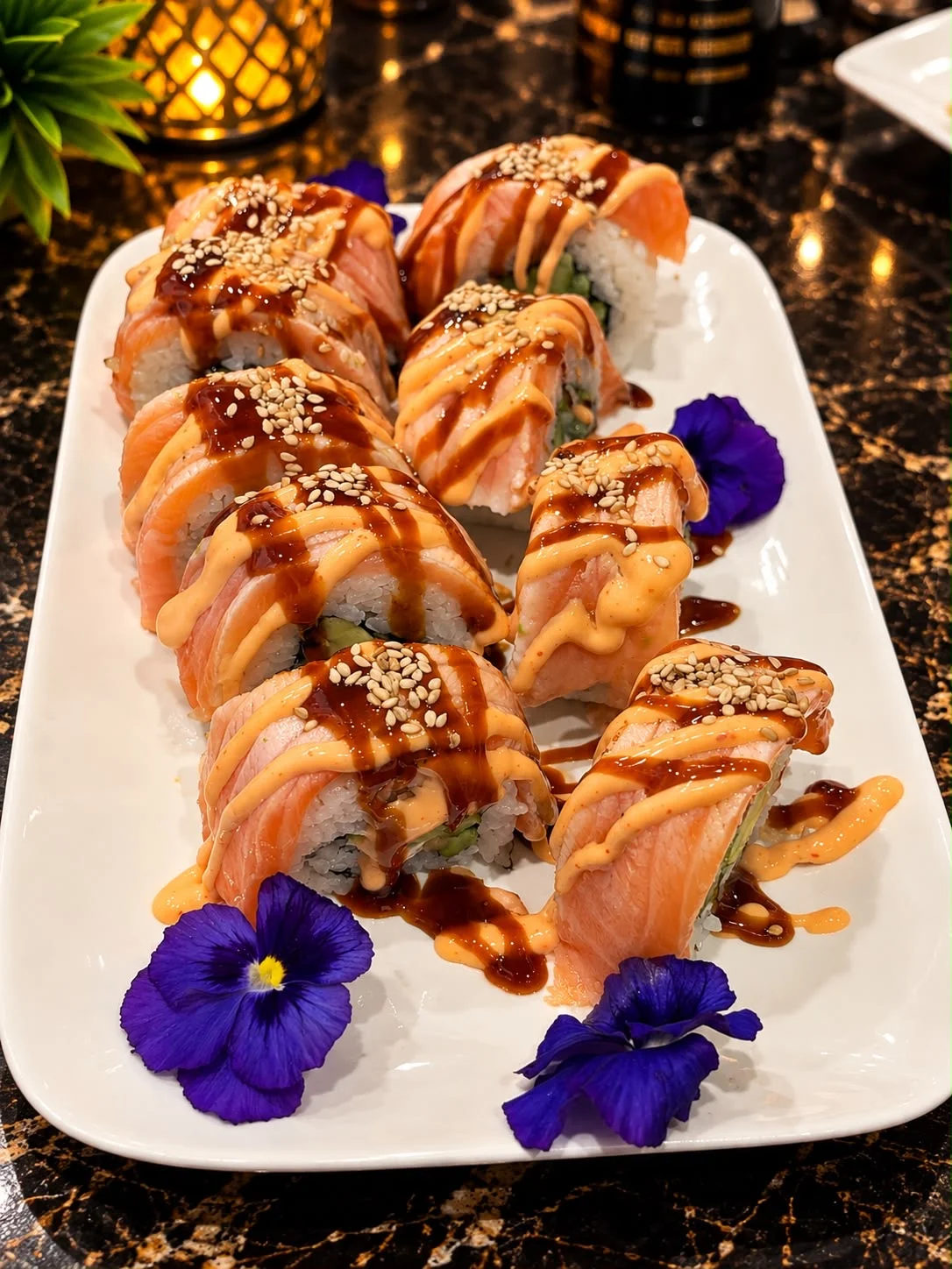 Sushi-Rolls mit Lachs, Sesam, Sauce und Blüten